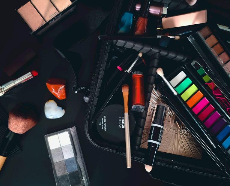 a variety of cosmetics and makeup brushes on a table